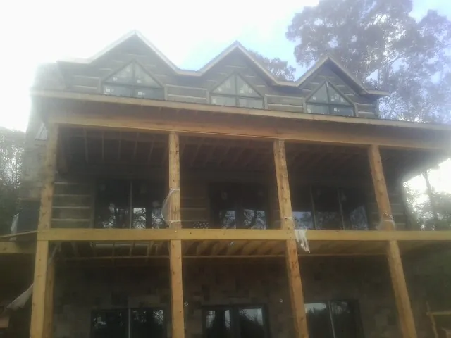 Dormers and porch framing on a large log home under construction — Roof Coating work by our crew in Ararat